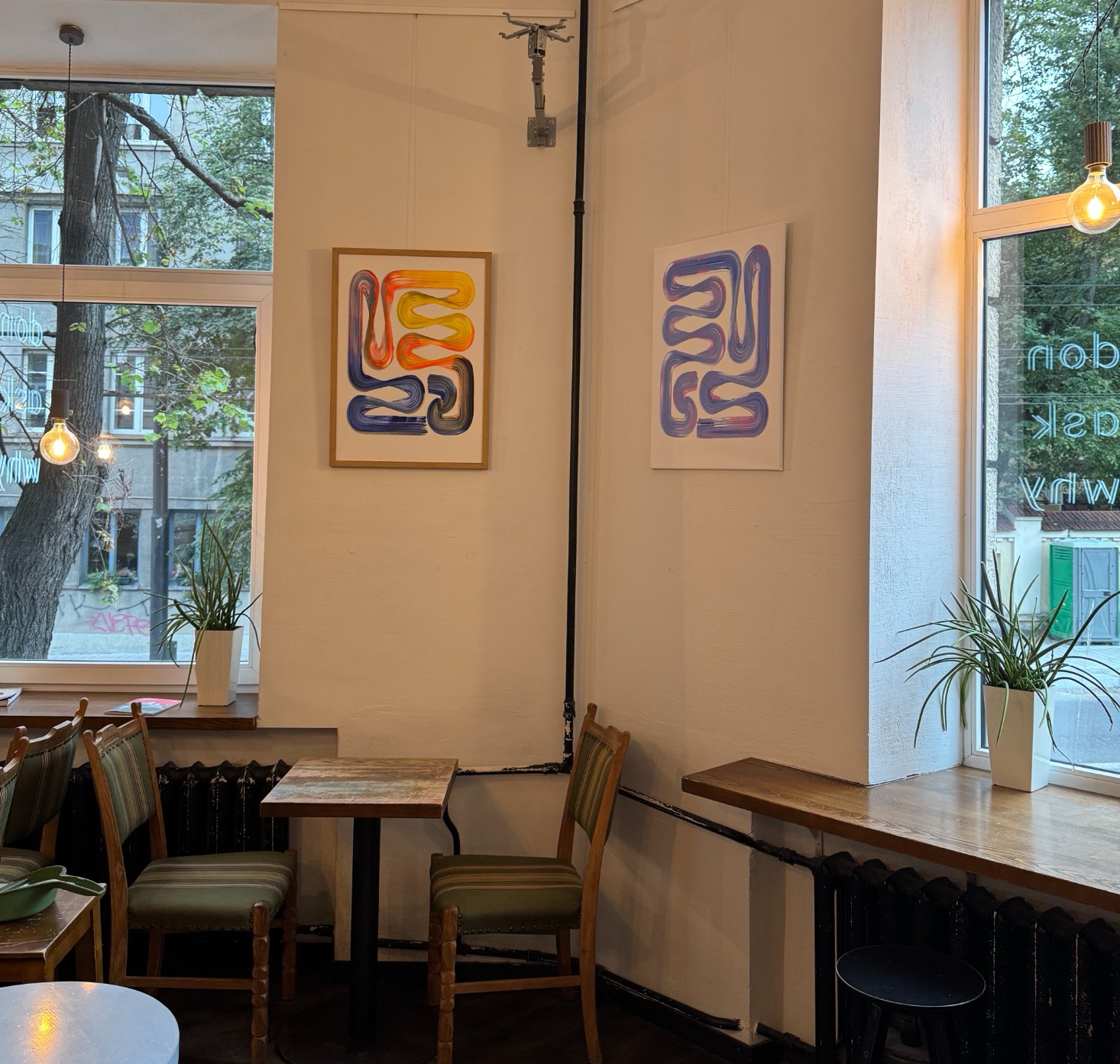 Lineage paintings displayed across two walls inside Elska Coffee in Vilnius